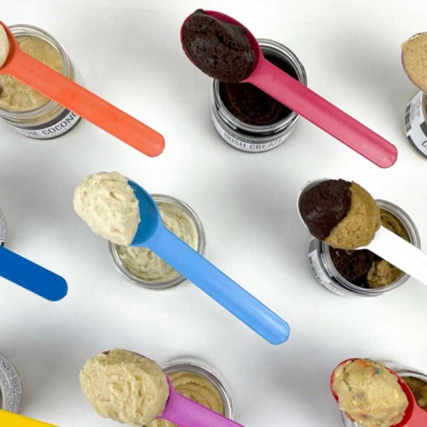 Overhead All flavors of Edible Cookie Dough with dough in spoons